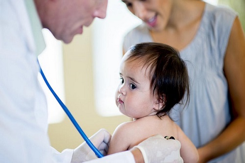 در تصویر یک نوزاد در حال معاینه پزشک برای تشخیص علت خس خس سینه نشان داده شده است.