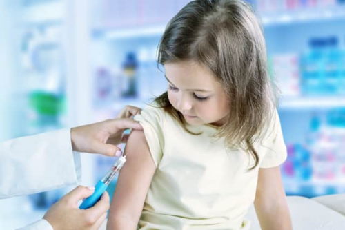 واکسن فلج اطفال در حال تزریق به یک کودک نمایش داده شده است.