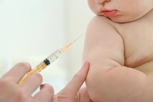 نوزاد دوماهه در حال دریافت واکسن نمایش داده شده است.