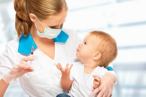 پزشک در حال تزریق واکسن 18 ماهگی به نوزاد نشان داده شده است.