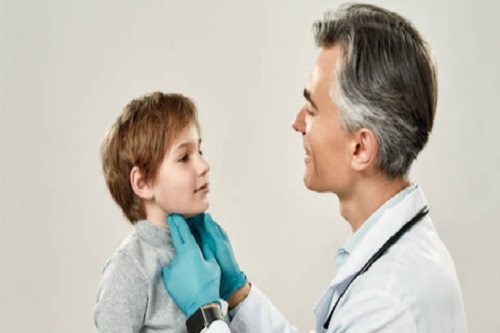 پزشک در حال معاینه کودک مبتلا به تیروئید مراجعه شده است.
